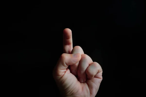 index finger pointing at the screen, black background