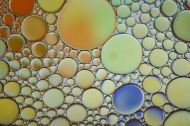 Suyun üzerinde çok renkli yağ halkaları, renkli arkaplan 