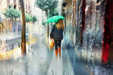 people with an umbrella in rainy days in winter season, bilbao, basque country, spain 