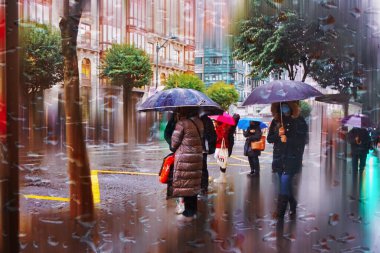 people with an umbrella in rainy days in winter season, bilbao, basque country, spain 