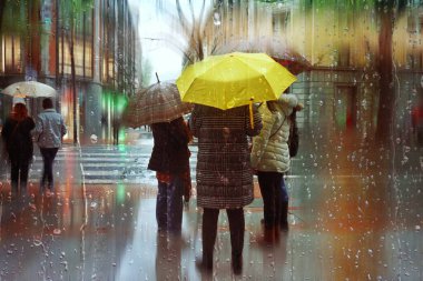 people with an umbrella in rainy days in winter season, bilbao, basque country, spain 