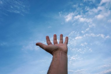 hand up gesturing in the blue sky, feelings and emotions