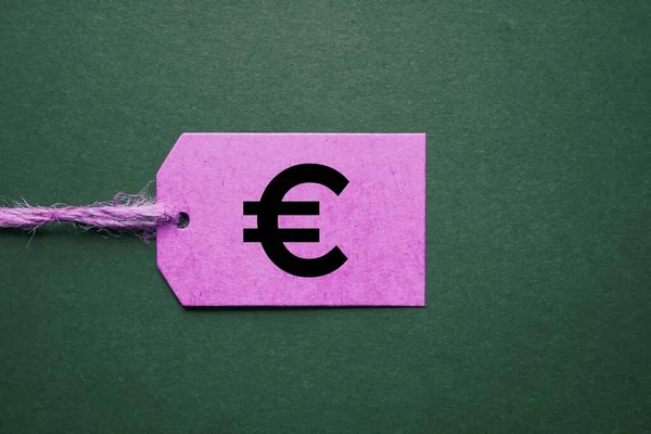 緑の背景にピンクの値札のユーロ記号 ロイヤリティフリーのストック写真