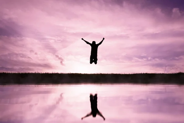 Homem Saltando Sobre Uma Lagoa Com Fundo Por Sol — Fotografia de Stock