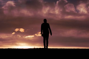 Yazın ve günbatımında kırsalda insan silueti 