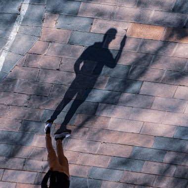 Bilbao sokaklarında yürüyen insanların gölgeleri. 