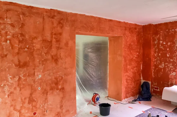 Renovation of a flat with red primer paint on the walls