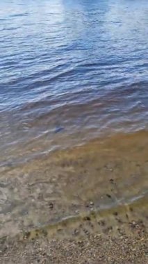 Su yüzeyinin detaylı yakın görüntüsü dalgalar, dalgalar ve güneş ışığı yüzeye yansıyor.