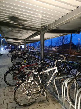 Kiel, Almanya - 25. Kasım 2022: Bisikletler geceleyin kentteki bir park yerinde