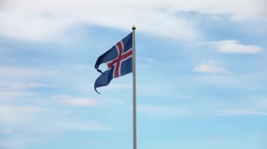 Güzel havada rüzgarda dalgalanan bayrak direğinde bir İzlanda bayrağı..