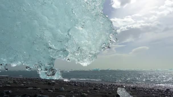 冰岛的钻石海滩 蓝色的冰山在黑色的沙滩上融化 冰上闪烁着阳光 — 图库视频影像