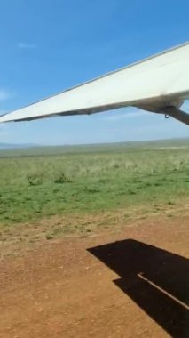 View from an aircraft onto the wing and the savannah in Kenya below.