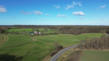 Aerial view of a drone of a forest and farmland with small country roads and farms in between.