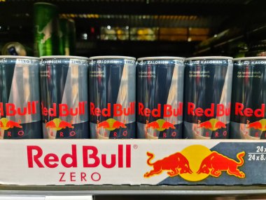 Kiel, Almanya - 03 Nisan 2023: Bir süpermarket rafında bir avuç dolusu Red Bull içecek kutusu