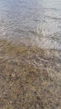 Dalgalar ve dalgalarla su yüzeyi ve güneş ışığı yüzeye yansıyor..