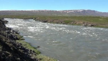 İzlanda 'da akan nehirlerle, kayalarla ve otlarla dolu harika bir manzara..