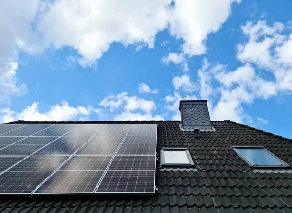 在住宅屋顶上生产清洁能源的太阳能电池板 — 图库照片