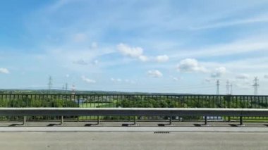 Göle ve park alanına bakarken hızlı giden bir arabanın yan camından dışarı bak