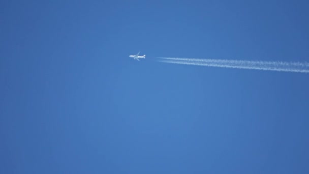 Gökyüzünde Yükseklerde Uçan Jet Uçağı Açık Mavi Gökyüzünde Kontrastlar Bırakır — Stok video