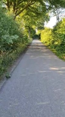 Yavaş sürüş yapan bir bisikletten köy yoluna bak.