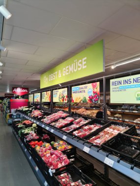 Kiel, Almanya - 27. Eylül 2023: Bir Alman süpermarketinde birçok ürünün bulunduğu büyük bir süpermarket rafı boyunca görüntüle