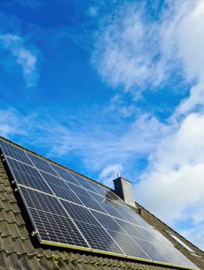 Solar panels producing clean energy on a roof of a residential house clipart