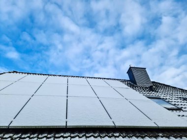 Kar, yerleşim yerinin çatısında temiz enerji üreten güneş panellerini kapladı.