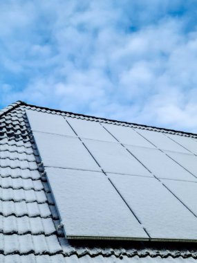 Kar, yerleşim yerinin çatısında temiz enerji üreten güneş panellerini kapladı.