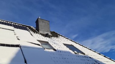 Kar, yerleşim yerinin çatısında temiz enerji üreten güneş panellerini kapladı..