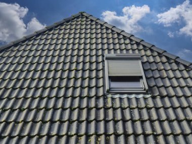 Siyah çatı kiremitleri ile Velux tarzı çatı penceresini aç