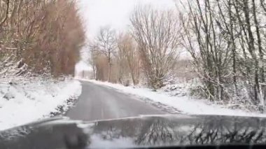 Hareket halindeki bir arabadan karla kaplı bir yola bak..