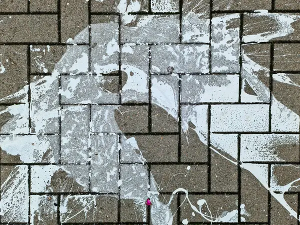 Paving stones from above with paint splatters and splatters of paint on them