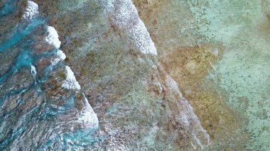 Hint Okyanusu 'nun dalgalarının altındaki mercan resifleriyle Maldivler' in cennet adalarının insansız hava aracı görüntüsü.