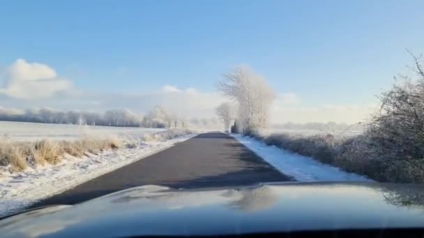 从挡风玻璃上看到一辆移动的汽车停在白雪覆盖的乡间路上 — 图库视频影像