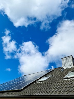 Solar panels producing clean energy on a roof of a residential house clipart