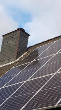 Siyah kiremit çatısındaki güneş panelleri üzerindeki bulut yansımalarının zaman akışı