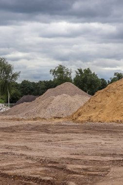 Kum ve lastik izleriyle dolu bir çakıl ocağına bak