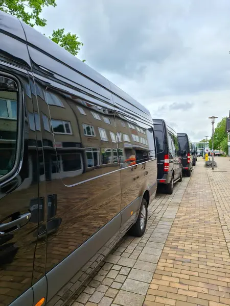 Neumuenster, Almanya - 04. Mayıs 2024: Mercesdes Benz 'den çok sayıda siyah minibüs alışveriş caddesi boyunca bir sırada park halinde.