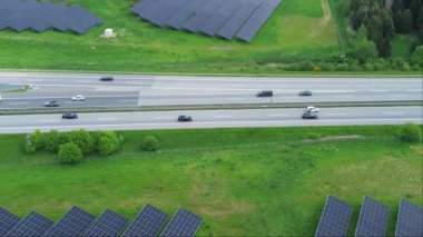 Bir Alman otoyolunda insansız hava aracı uçuşu. Çok fazla trafik ve yol kenarında büyük güneş panelleri var..