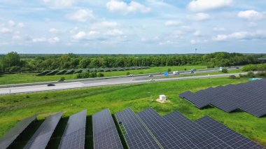 Bir Alman otoyolunda insansız hava aracı uçuşu. Çok fazla trafik ve yol kenarında büyük güneş panelleri var.