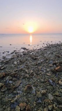 Rüya gibi bir gün batımı Maldivler sahilindeki suya yansıyor.