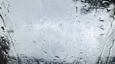Şiddetli yağmurda arabanın ön camından ön cama birçok damla damlatarak görüntüle.