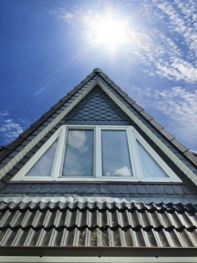Siyah çatı kiremitleri ile Velux tarzı çatı penceresini aç