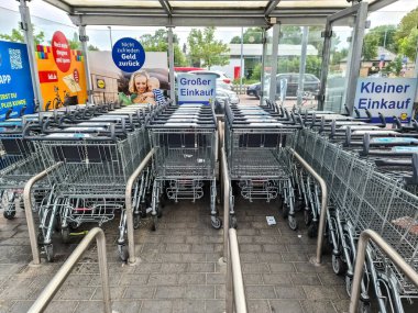 Kiel, Almanya - 26 Haziran 2024: Lidl süpermarketinin açık alanındaki alışveriş arabaları için otopark