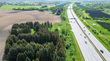 Alman otoyolu A7 'nin insansız hava aracı görüntüsü ve yeşil bir arazide bazı arabalar ve trafik