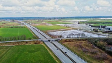 Alman otoyolu A7 'nin insansız hava aracı görüntüsü ve yeşil bir arazide bazı arabalar ve trafik