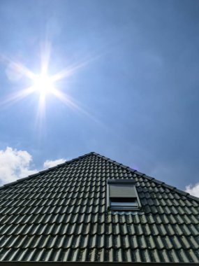 Siyah çatı kiremitleri ile Velux tarzı çatı penceresini aç