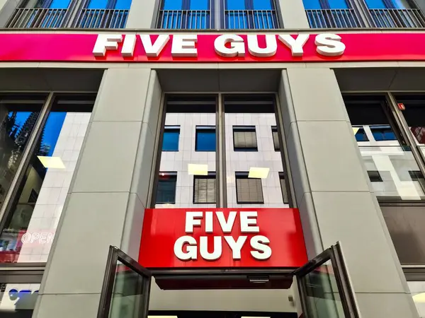 stock image Cologne, Germany - 08 August 2024: The entrance area of a Five Guys brand store with two logos above the entrance