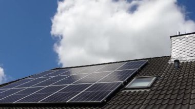 Güneş ışığındaki bir yerleşim yerinin çatısındaki bir güneş sisteminin zaman atlamalı kaydı..