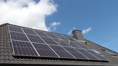 Güneş ışığındaki bir yerleşim yerinin çatısındaki bir güneş sisteminin zaman atlamalı kaydı..